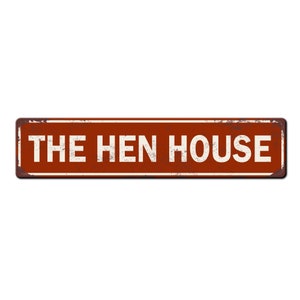 May include: A rusty red metal sign with white text that reads "THE HEN HOUSE".