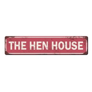May include: A red metal sign with white text that reads "THE HEN HOUSE". The sign has a distressed, rusty look.