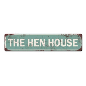 May include: A rustic green metal sign with white text that reads "THE HEN HOUSE".