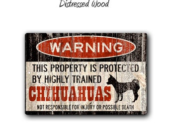 May include: A rectangular wooden sign with a distressed finish. The sign features the word "WARNING" in a red oval, and text stating "THIS PROPERTY IS PROTECTED BY HIGHLY TRAINED CHIHUAHUAS". A black silhouette of a Chihuahua is also present.