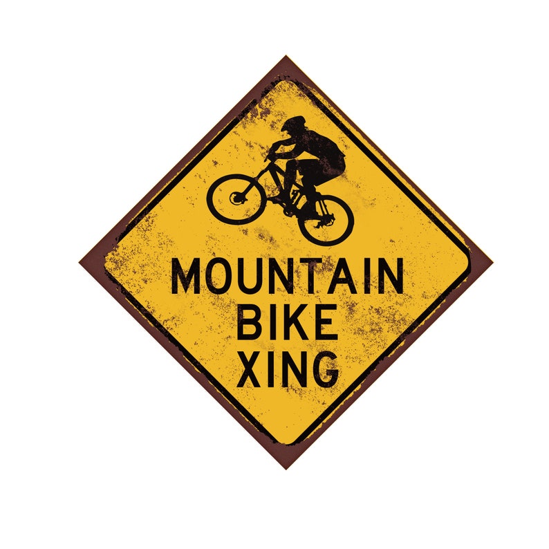 Op de afbeelding: Een geel ruitvormig bord met een verweerde, roestige uitstraling. Het bord heeft de tekst "Mountain Bike Xing" en toont een silhouet van een persoon die een mountainbike rijdt.
