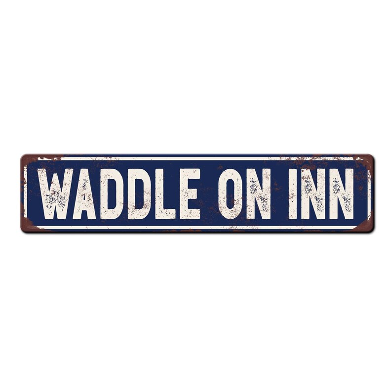 May include: A blue and white metal sign with the text "Waddle On Inn" in white lettering. The sign has a rustic, weathered look.
