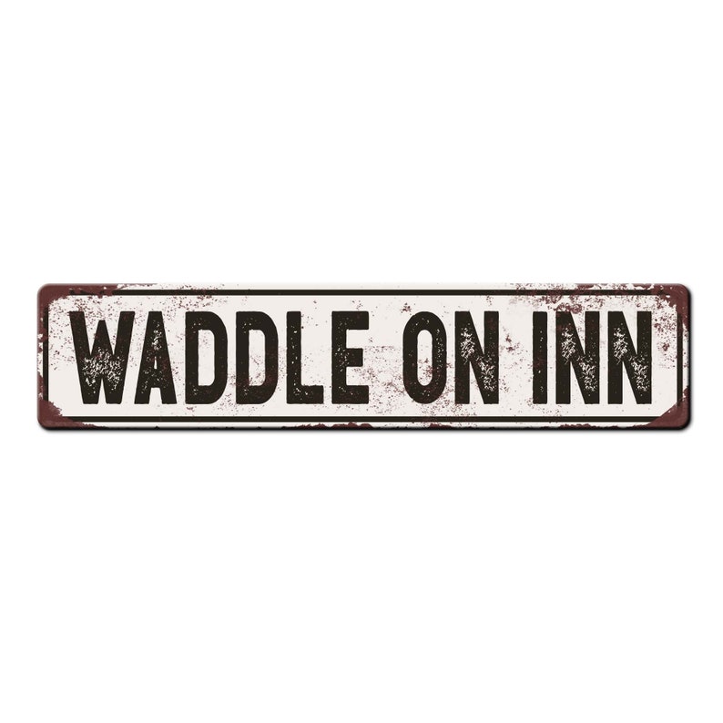 May include: A white metal sign with a rustic, weathered look. The sign has black text that reads "Waddle On Inn".