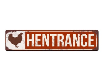 May include: A rusty metal sign with a white background and red border. The sign says "Hentrance" in white letters and has a silhouette of a chicken on the left side.