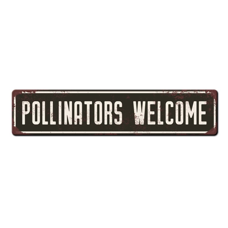 May include: A rusty metal sign with black lettering that reads "Pollinators Welcome".