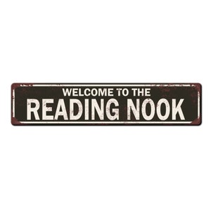 May include: A rusty metal sign with black background and white text that reads "Welcome to the Reading Nook".