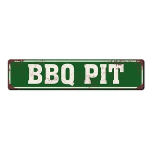 Pode incluir: Uma placa de metal verde com o texto "BBQ PIT" em letras brancas. A placa tem um aspecto r&uacute;stico e desgastado.