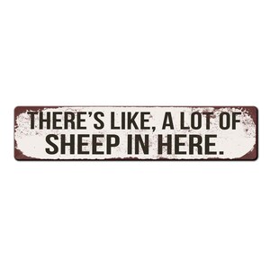 Puede incluir: Un letrero de metal blanco con un borde marrón oxidado y desgastado. El letrero dice "There's like, a lot of sheep in here."