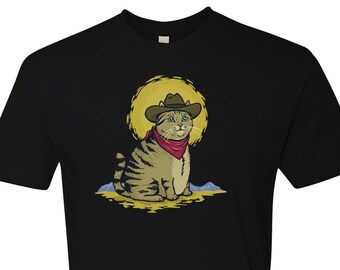 May include: A black t-shirt with a cartoon illustration of a cat wearing a cowboy hat and bandana. The cat is sitting in a desert landscape with a yellow sun behind it.