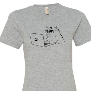 May include: Gray women's t-shirt with a black and white illustration of a cat wearing glasses and using a laptop.