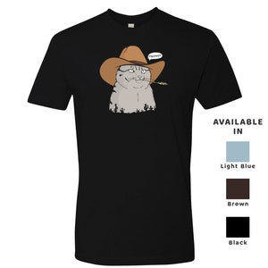 May include: Black t-shirt with a cartoon image of a cat wearing a cowboy hat and holding a piece of grass in its mouth. The cat is looking at the viewer and has a speech bubble above its head that says "MEOWDY". Available in light blue, brown, and black.