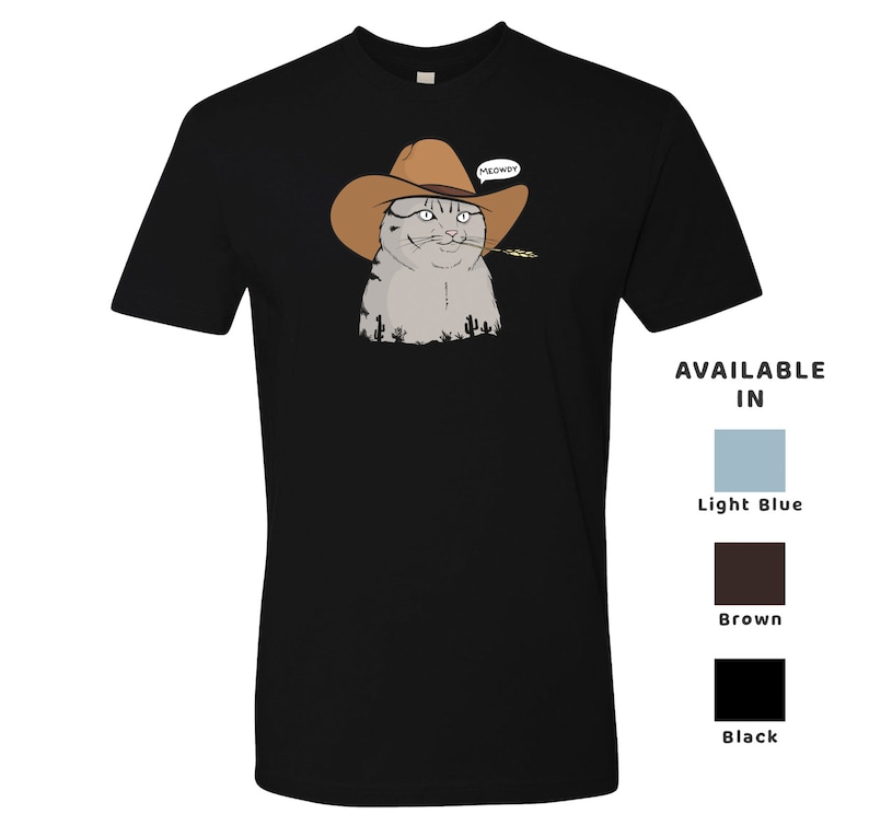 May include: Black t-shirt with a cartoon image of a cat wearing a cowboy hat and holding a piece of grass in its mouth. The cat is looking at the viewer and has a speech bubble above its head that says "MEOWDY". Available in light blue, brown, and black.