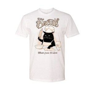 May include: White t-shirt with a black cat wearing a chef's hat and holding a rolling pin. The cat is making biscuits, with the text "Killy's Biscuits Made from Scratch" on the shirt.