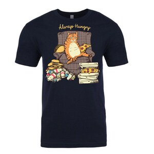 May include: A navy blue t-shirt with a graphic of an orange cat sitting in a chair with a pizza and a taco. The cat is surrounded by empty food containers and the text "Always Hungry" is printed above the cat.