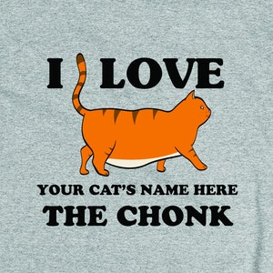 May include: A gray t-shirt with the text "I LOVE [YOUR CAT'S NAME HERE] THE CHONK" and a cartoon image of an orange tabby cat.