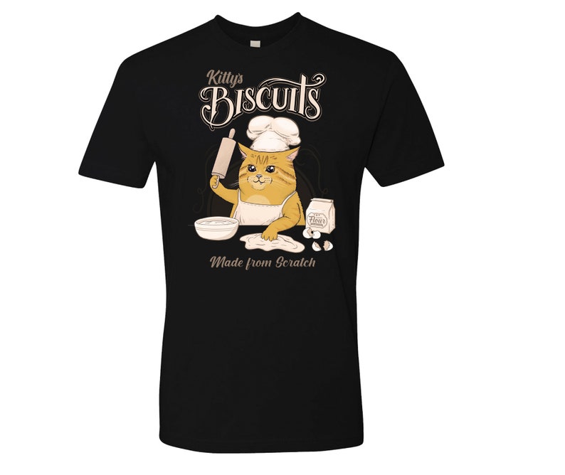 May include: Black t-shirt with a cartoon cat wearing a chef's hat and holding a rolling pin. The cat is making biscuits, with the text "Kitty's Biscuits Made from Scratch" on the shirt.