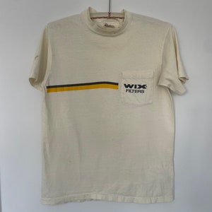 May include: A white t-shirt with a yellow and black stripe across the chest and a pocket on the right side. The pocket has the text "WIX FILTERS" printed on it.