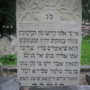 Puede incluir: Una lápida de piedra gris con texto hebreo tallado en ella. El texto dice: "i שי אלקי קדוש מון הקדמונים מוגלה עמוקות ורזין ומטמונים הוא שאומרים עליו שדיבר אתו אליהו פנים אל פנים הגאון אבד ורמ מו נתן נטען בן מוה שלמה שפירא זצל כפטר ביום דיגאב שצג לפק".