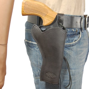 May include: Black leather holster with a wooden-handled revolver. The holster is attached to a black belt worn with blue jeans. The revolver's grip is a light brown color.