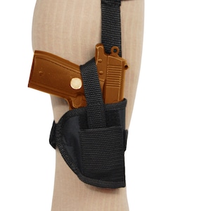 以下が含まれることがあります： 茶色の拳銃が収納された黒い足首用ホルスター。ホルスターは、安全なフィット感のために調節可能なストラップが付いています。