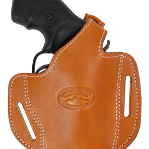 May include: A brown leather holster with white stitching for a revolver. The holster has two belt loops and a maker's mark that reads "Parsons Leather Hand Crafted American Co."