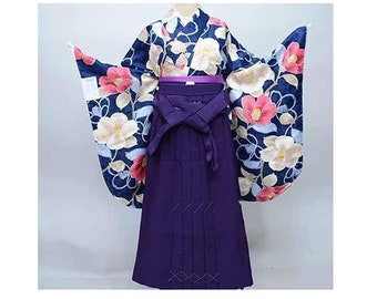 May include: A traditional Japanese kimono with a dark blue background and a floral pattern. The kimono has long sleeves and a wide, flowing skirt. The kimono is paired with a purple obi, a sash worn around the waist.