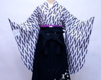 May include: A black and white patterned kimono with long sleeves and a black hakama with white flower embroidery. The kimono has a purple sash.