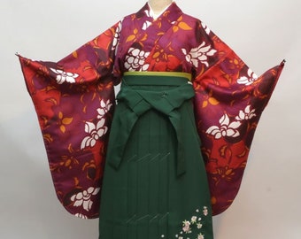 May include: A green and red Japanese kimono with a floral pattern. The kimono has a long, flowing skirt and a wide, flowing sleeve. The kimono is decorated with white flowers and gold accents.