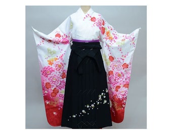 May include: A white kimono with pink and red floral patterns, paired with a black hakama skirt. The kimono has a purple sash and the hakama has white floral embroidery.