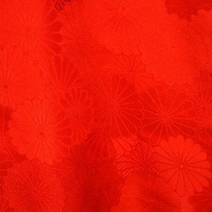 May include: Red fabric with a repeating pattern of stylised flowers.