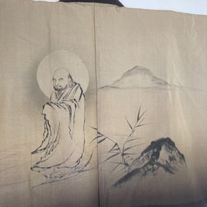 May include: A traditional Japanese kimono with a black collar and a beige background. The kimono features a hand-painted design of a man meditating in a mountain landscape with bamboo.