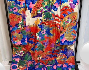 Könnte beinhalten: Ein traditioneller japanischer Kimono mit weißem Hintergrund und einem farbenfrohen Blumenmuster. Der Kimono ist in den Farben Rot, Blau, Gold und Grün gehalten. Das Muster umfasst Blumen, Vögel und Wellen.