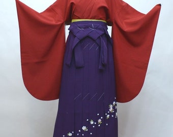 May include: A red and purple Japanese kimono with white floral embroidery. The kimono has long sleeves and a wide sash.