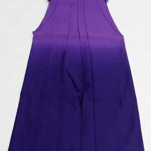 May include: A purple and dark purple ombre hakama with pleats and a tie at the waist.