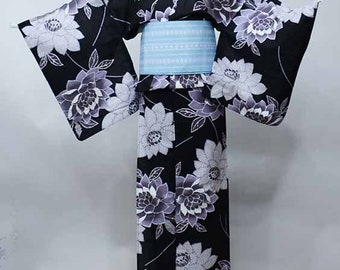 May include: A black and white yukata with a floral pattern. The yukata has a blue obi.