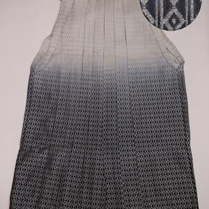 May include: A black and white hakama with a gradient pattern. The hakama is made of a silky fabric and has a traditional Japanese design. The fabric has a geometric pattern.