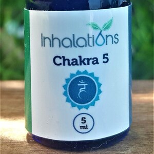 以下が含まれることがあります： 黒いキャップが付いた小さな青いガラス瓶で、ラベルには「Inhalations Chakra 5」と、青とターコイズのシンボルと「5 ml」が印刷されています。