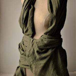 the drab green shawl is wrapped around the shoulder and around the waist