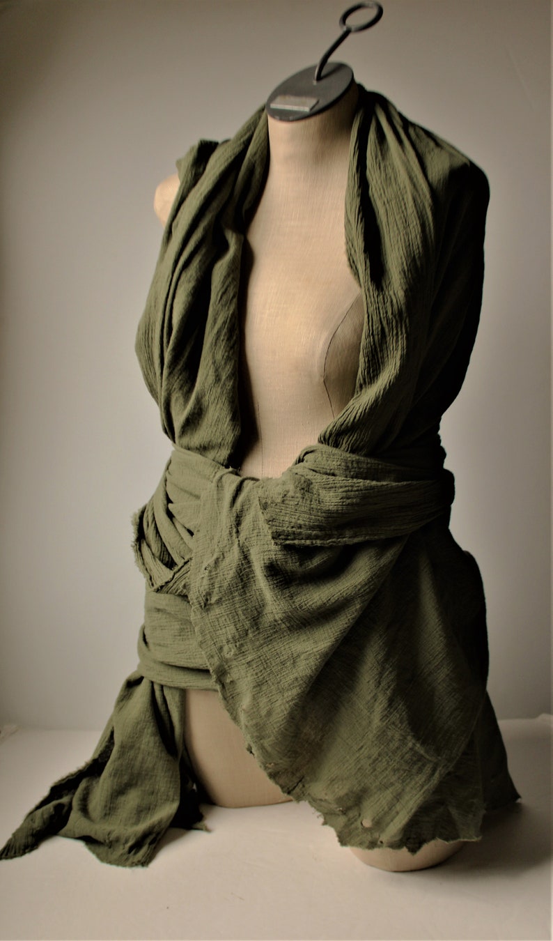 the drab green shawl is wrapped around the shoulder and around the waist