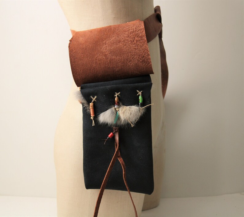 May include: A brown leather belt with a brown leather pouch attached. The pouch has a drawstring closure. The belt has a decorative beaded strap with colorful beads. The bag could carry a cell phone in it at a Ren Faire.