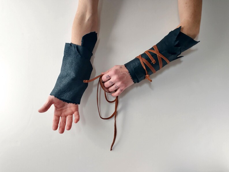 dark sheepskin arm wraps with leather straps untying