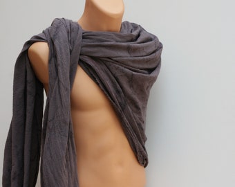 May include: A draped, gray scarf made of a textured fabric. The scarf is wrapped around a mannequin torso, showcasing its flow and drape. The fabric appears soft and lightweight, with subtle variations in color.