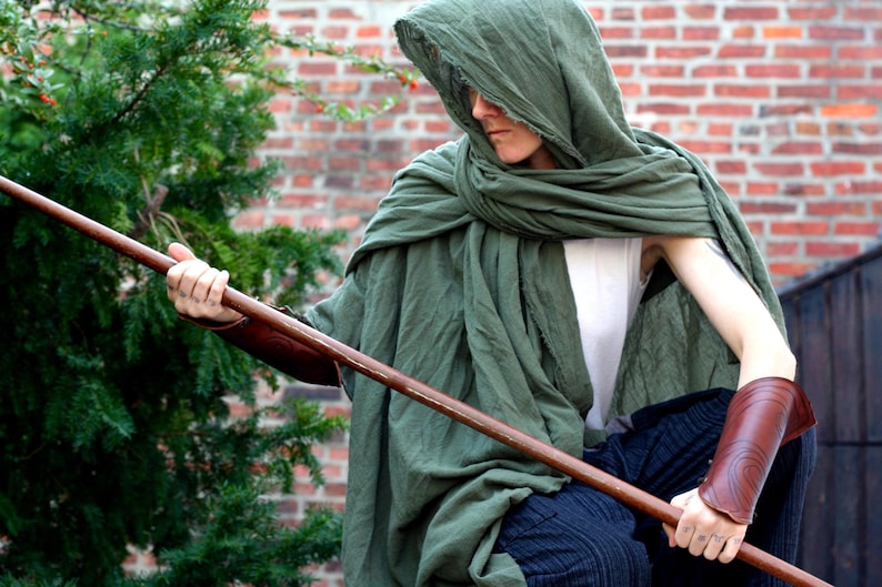 drab green distressed cotton cloak wrapped around the shoulders and over the head as a hood