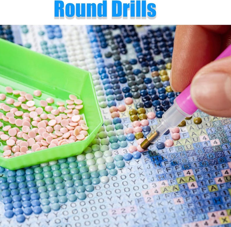 May include: A diamond painting project in progress is shown. A green tray holds light pink round drills, a pink stylus is in use, and a canvas is partially complete with various coloured drills. The text "Round Drills" is at the top of the image.