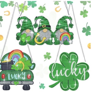 May include: Four diamond painting kits featuring St. Patrick's Day themes. The kits include a green car with a rainbow and pot of gold, a four-leaf clover with the word "lucky", and two gnomes with shamrocks and rainbows.