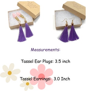 May include: Earrings and earplugs with purple tassels. The earrings have gold-coloured hooks and the earplugs have pink ear tips. The tassel earrings are 7.6 cm long, and the earplugs are 8.9 cm long. Both are displayed in small, open cardboard boxes.