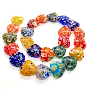 May include: A strand of colorful heart-shaped glass beads with intricate patterns. The beads are made of Murano glass and feature a variety of colors, including red, blue, green, yellow, and white.