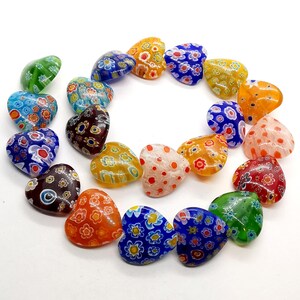 May include: A collection of colorful heart-shaped glass beads with intricate floral patterns. The beads are made of Murano glass and are perfect for jewelry making or crafting.