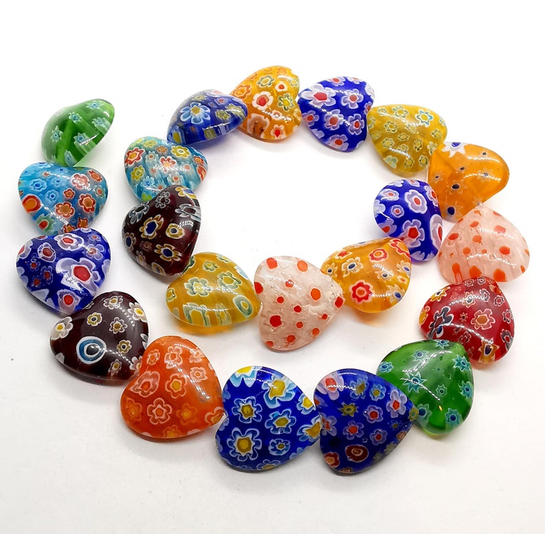 May include: A collection of colorful heart-shaped glass beads with intricate floral patterns. The beads are made of Murano glass and are perfect for jewelry making or crafting.