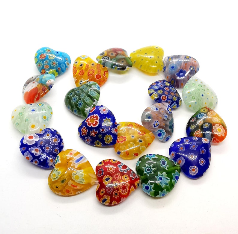 May include: A collection of colorful heart-shaped glass beads with intricate floral patterns. The beads are made of Murano glass and are perfect for jewelry making or crafting.